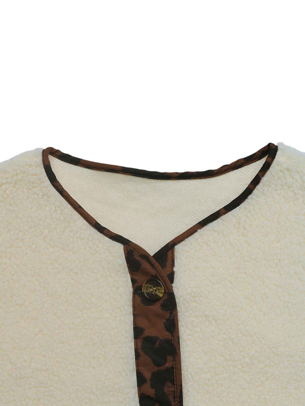 Close-up of a cream-colored textured fleece garment with a brown and black leopard-print trim along the neckline and front placket, featuring a single gold-tone button.