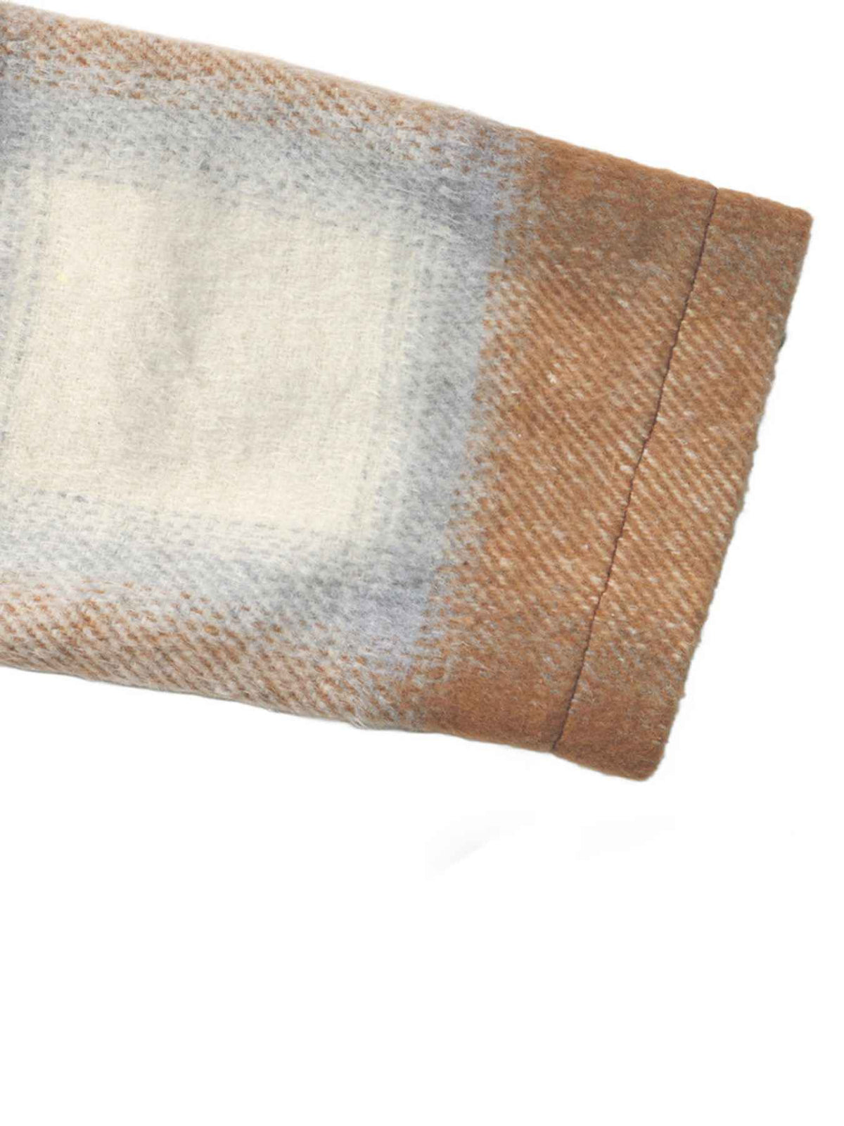 A close-up of a folded plaid fabric item, showing a woven pattern with beige, brown, and light gray tones on a white background.