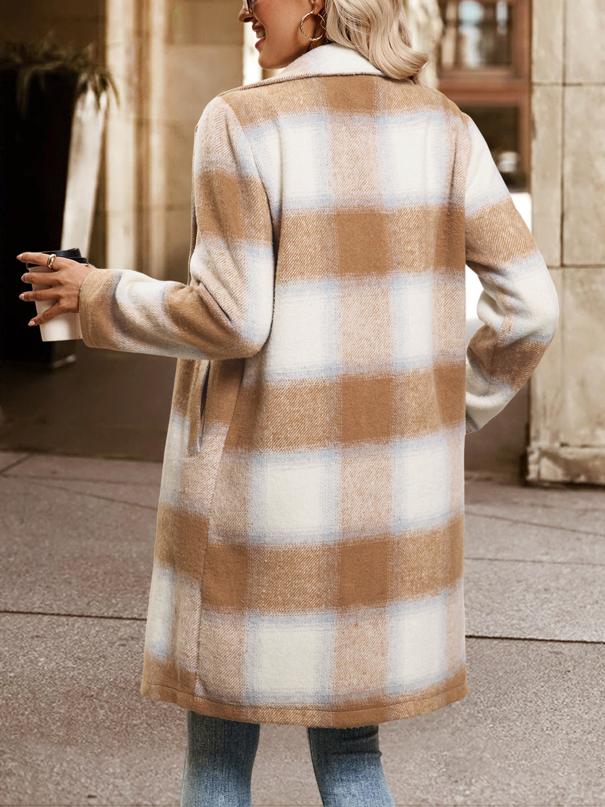 Person wearing a plaid coat outdoors on a sidewalk.