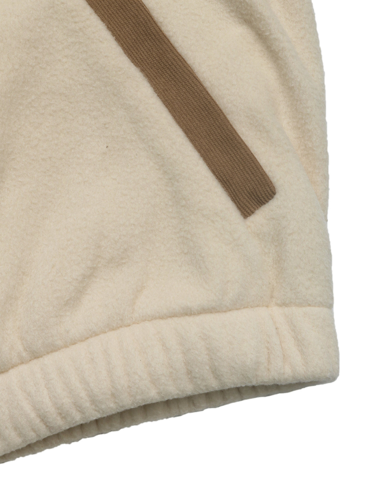 Close-up of a cream-colored fleece garment with a ribbed cuff and a diagonal brown stripe detail, shown against a white background.