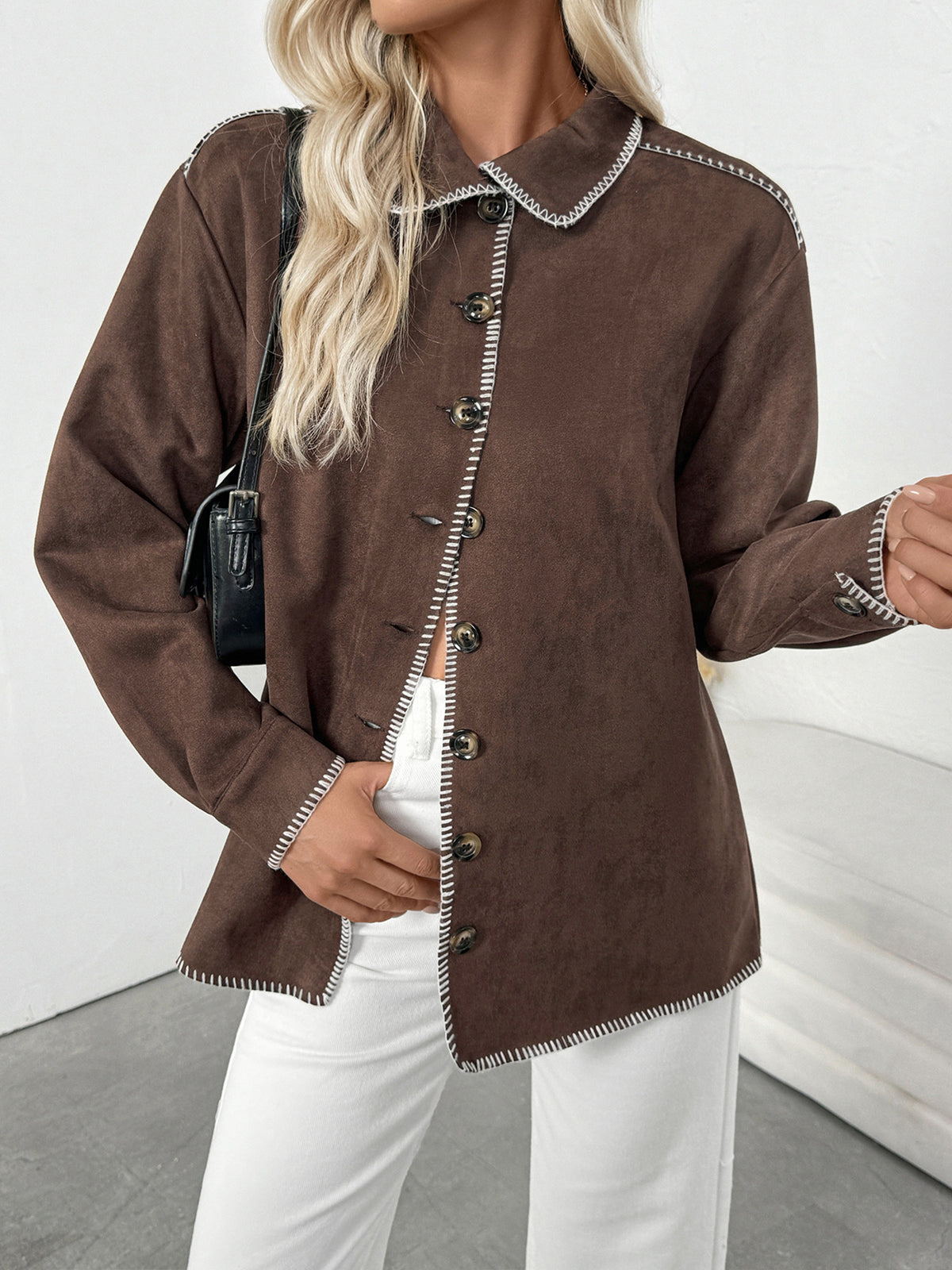 Brown jacket with white trim worn by a person on a plain background
