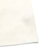 Close-up of a cream-colored knit fabric with a ribbed cuff, showing the fine knit texture against a white background.