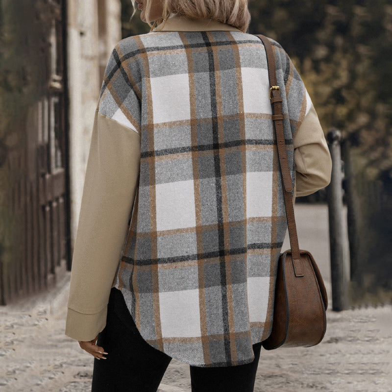Person wearing a plaid vest and carrying a brown bag on a street.