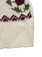 Close-up of a knitted garment with a patterned edge on a white background