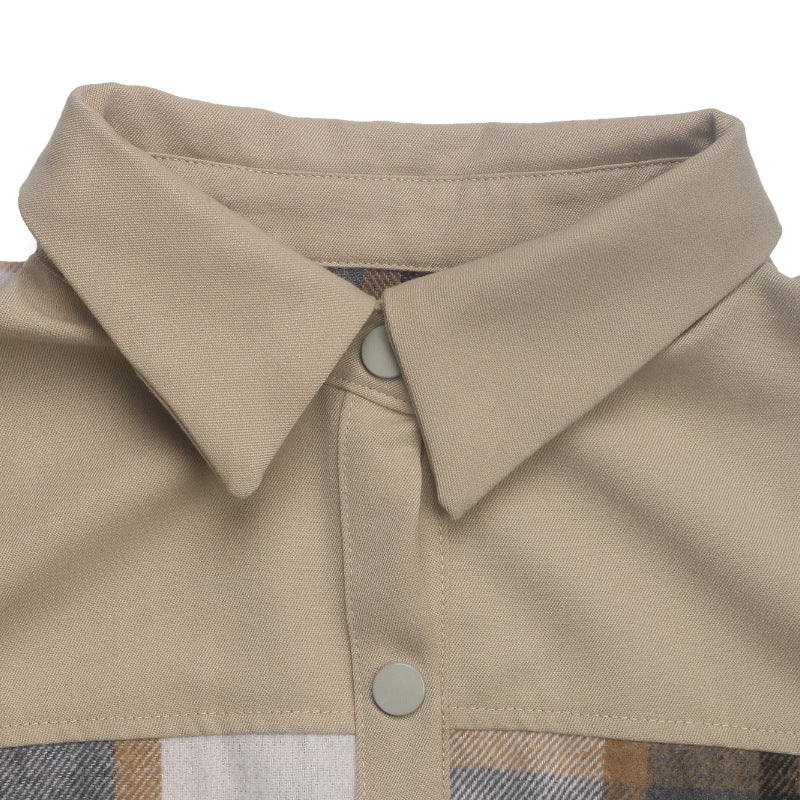 Close-up of a beige collared shirt with a plaid patterned panel at the bottom and light gray buttons, shown on a white background.