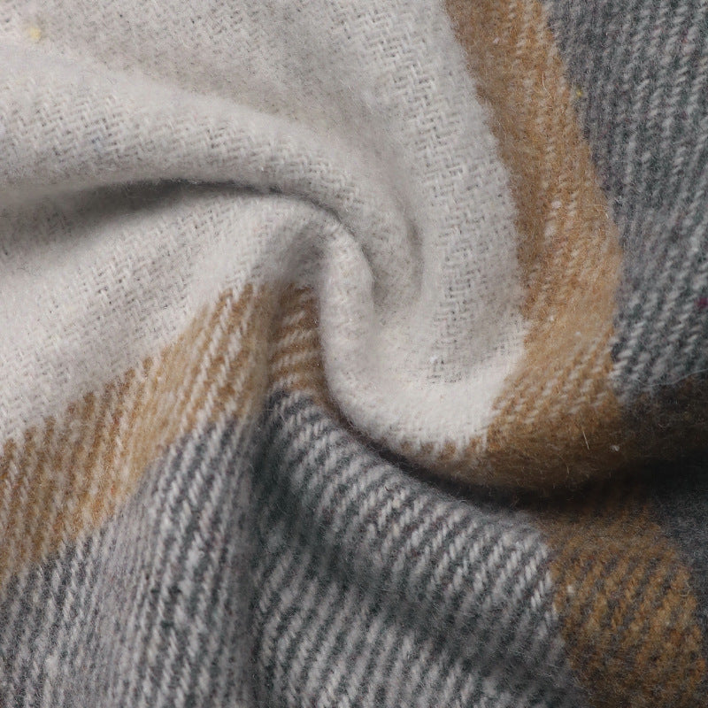 A close-up of a soft woven fabric with a plaid pattern in off-white, gray, and warm tan.
