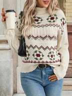 Woman wearing a patterned sweater holding a coffee cup outdoors.
