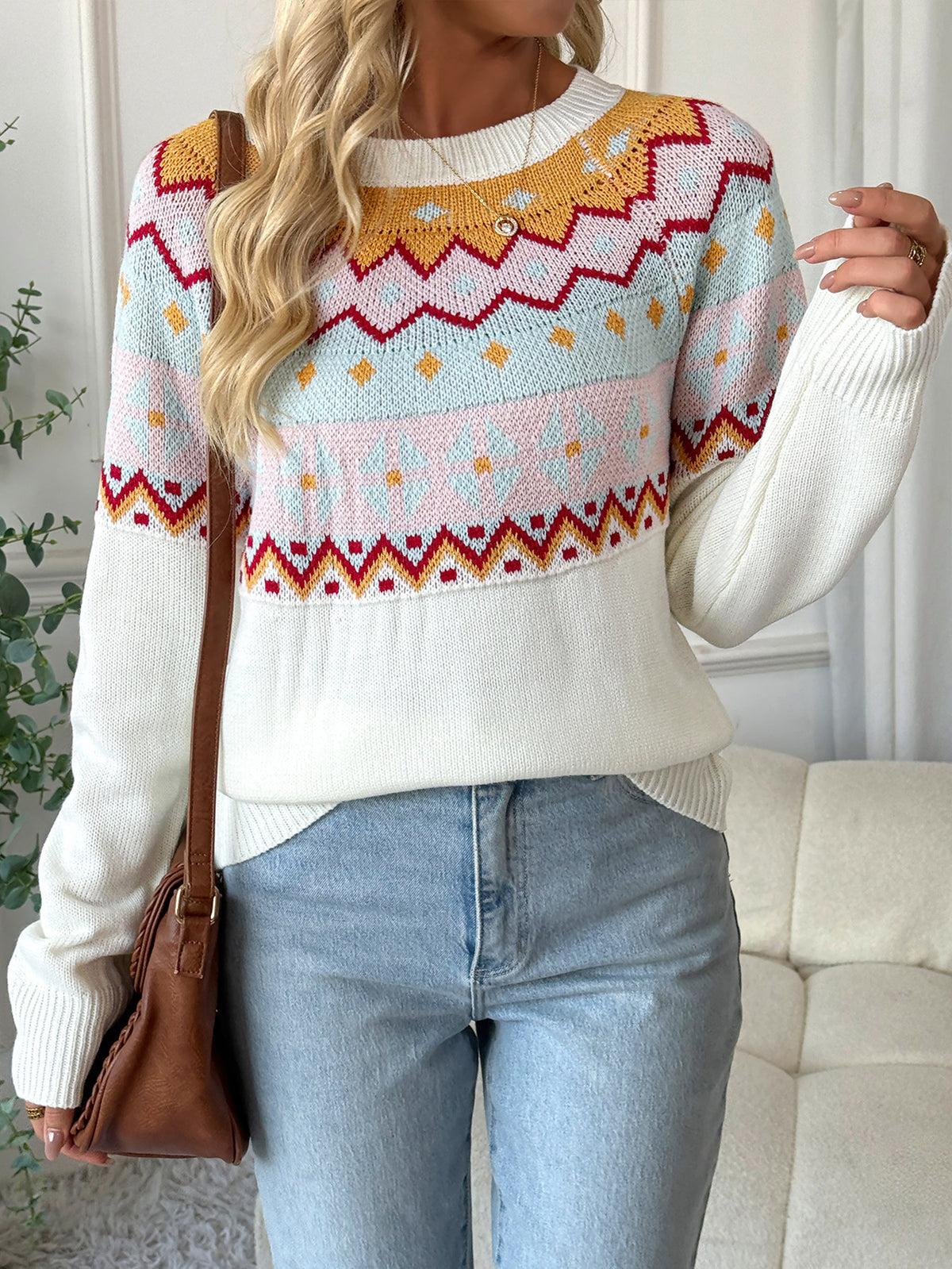 Person wearing a colorful patterned sweater with a neutral background