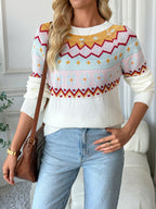 Woman wearing a colorful patterned sweater and light blue jeans indoors.